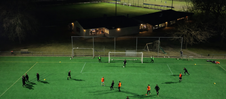 Het non-fill kunstgrasveld in de avond gefotografeerd met een drone
