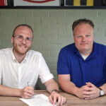 Liam Engel tekent het contract waarmee hij de nieuwe trainer wordt van Dames 1 van v.v. Albatross. Voorzitter Basitaan Bakker zit naast hem.