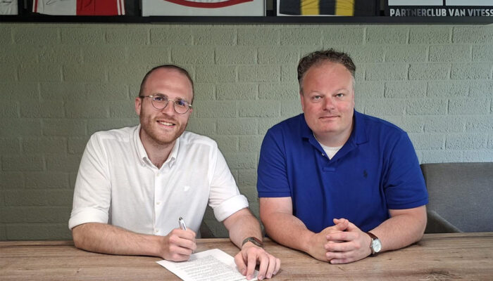 Liam Engel tekent het contract waarmee hij de nieuwe trainer wordt van Dames 1 van v.v. Albatross. Voorzitter Basitaan Bakker zit naast hem.