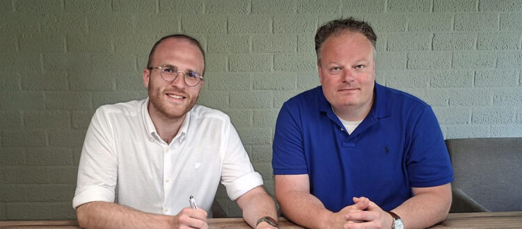 Liam Engel tekent het contract waarmee hij de nieuwe trainer wordt van Dames 1 van v.v. Albatross. Voorzitter Basitaan Bakker zit naast hem.